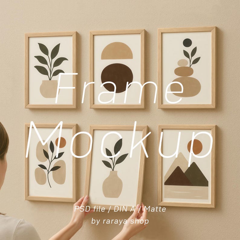 May include: A set of six framed prints with abstract designs in shades of brown, beige, and black. The prints feature geometric shapes, plants, and mountains. The frames are made of wood and have a natural finish. The text "Frame Mockup" is written in large letters across the middle of the image. The text "PSD file / DIN A4 / Matte by raraya shop" is written in smaller letters at the bottom of the image.
