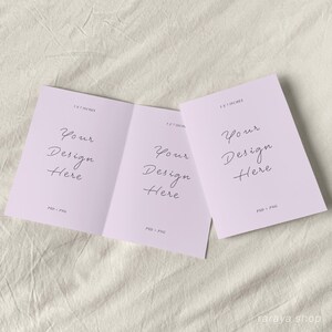 May include: A folded card mockup with a light purple background. The card is 5.5 x 7 inches and has the text "Your Design Here" on each side. The text is in a handwritten font.