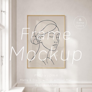 Könnte beinhalten: Ein Mockup eines gerahmten Strichzeichnung eines Frauen Gesichts. Der Rahmen ist in hellem Holzton gehalten und der Hintergrund ist eine weiße Wand. Der Text "Frame Mockup" ist in weißen Buchstaben auf dem Bild geschrieben. Der Text "PSD file / DIN A" ist in schwarzen Buchstaben unter dem Bild geschrieben. Der Text "Matte & Glass, with or without Mat" ist in schwarzen Buchstaben unter dem vorherigen Text geschrieben. Der Text "by ralaya shop" ist in schwarzen Buchstaben unter dem vorherigen Text geschrieben.