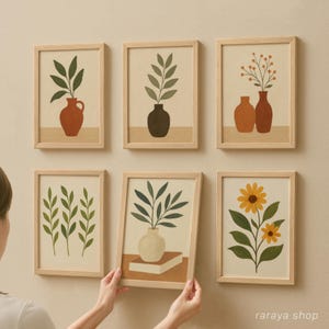 May include: Six framed prints with minimalist botanical illustrations. The prints feature various plants and flowers in vases, including a sunflower, a leafy branch, and a sprig of berries. The frames are all light wood and have a simple, modern design.