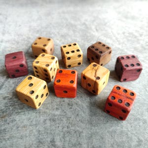 May include: A set of ten wooden dice in various colors, including red, orange, yellow, brown, and purple. The dice are all the same size and have black dots on each side.
