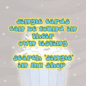 May include: A blue and yellow graphic with a cartoon cupcake and the text "single cards can be found in their own listing search 'single' in my shop".