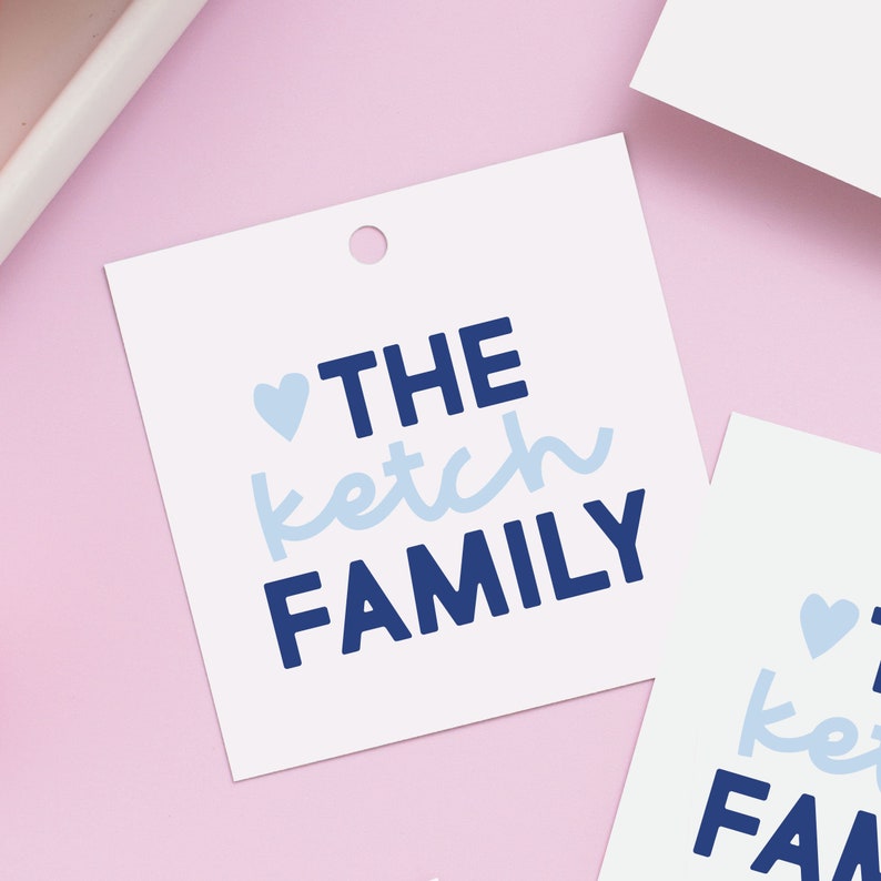 May include: White gift tag with a blue heart and the text "THE ketch FAMILY" in blue lettering.