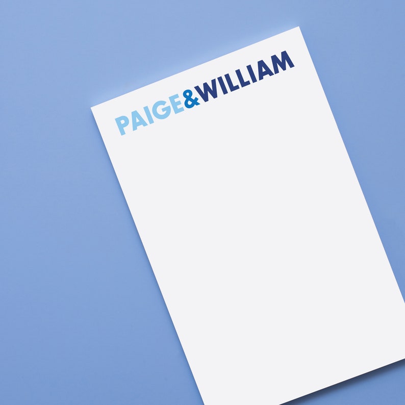 Puede incluir: Un bloc de notas blanco con el texto "PAIGE & WILLIAM" impreso en letras azules y azul claro.