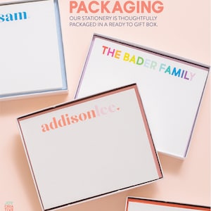 May include: A set of four personalized stationery note cards in white boxes with colorful text. The text on the cards reads "sam", "THE BADER FAMILY", "addisonlee.", and "APRIL". The boxes are on a pink background. The text "PACKAGING OUR STATIONERY IS THOUGHTFULLY PACKAGED IN A READY TO GIFT BOX." is at the top of the image.