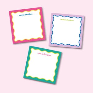 May include: Three colorful square notepads with scalloped edges. Each notepad has a different color background and a wavy border in a contrasting color. The text "rachel davidson" is printed in yellow on each notepad.