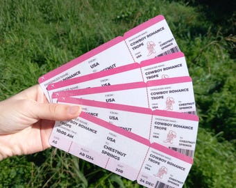 May include: A stack of pink airline boarding passes with the text "COWBOY ROMANCE TROPE" and "CHESTNUT SPRINGS".