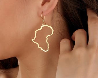 May include: Gold earrings shaped like the outline of the continent of Africa.