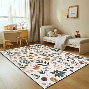 May include: A white rug with a pattern of green and brown leaves and pine cones. The rug is in a room with a white bed and a wooden desk.