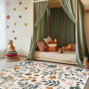May include: A white and green patterned rug with leaves and acorns. The rug is in front of a wooden bed with a green canopy and a fox cushion.