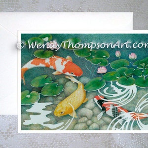 May include: A watercolor painting of three koi fish swimming in a pond with lily pads and pink flowers. The fish are orange, yellow, and black and white.