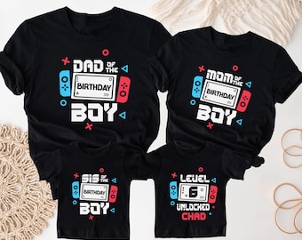 May include: Four black t-shirts with white, red, and blue graphics. The shirts read "DAD of the BIRTHDAY BOY", "MOM of the BIRTHDAY BOY", "SIS of the BIRTHDAY BOY", and "LEVEL 6 UNLOCKED CHAD". Each shirt features a video game controller design.