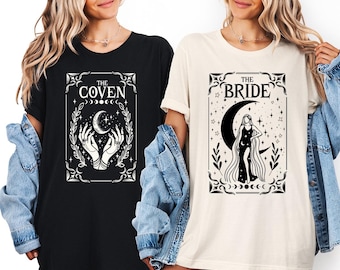 May include: Two t-shirts, one black and one cream-colored, featuring mystical designs. The black shirt displays "THE COVEN" with hands holding a crescent moon. The cream shirt shows "THE BRIDE" with a woman on a crescent moon.