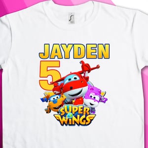 May include: White t-shirt with a blue and yellow "Jayden" text, a yellow number 5, and a graphic of cartoon characters from the show "Super Wings".