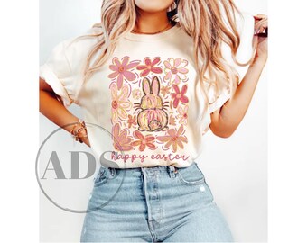 May include: A white t-shirt with a pink and yellow floral design featuring a bunny rabbit and the text "happy easter".