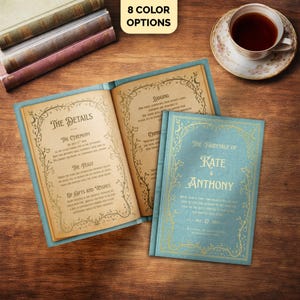 Può includere: Libri di invito a nozze aperti con copertine color teal e scritte dorate, con il testo "The Fairytale of Kate & Anthony". Il libro aperto mostra i dettagli del matrimonio. Una tazza di tè è vicina. L'immagine include il testo "8 Color Options".