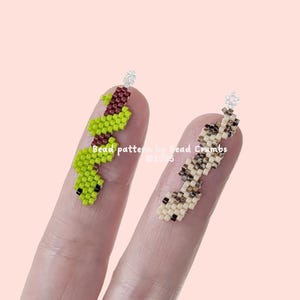 Puede incluir: Dos patrones de cuentas en los dedos, uno verde y rojo, el otro beige y marrón. "Bead patterns by Bead Crumbs @2023"