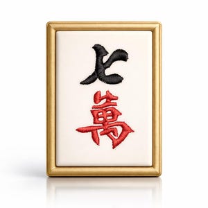 May include: A rectangular Mahjong tile with a gold frame. The tile features black and red embroidered Chinese characters on a white background. The characters are stylized and intricate, with a glossy finish.