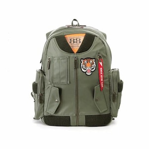 May include: Olive green backpack with multiple pockets and a front zip. It features a tiger patch, orange and black accents, and a red tag that reads "REMOVE BEFORE FLIGHT". The backpack has the number "88" on the front.