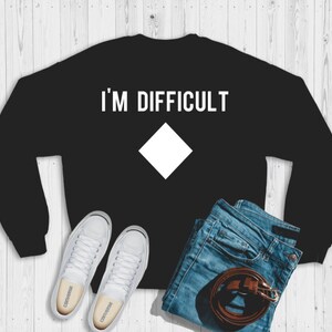May include: Black sweatshirt with white text that reads "I'm Difficult" and a white diamond shape.