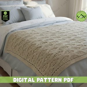 May include: A beige cable knit crocheted blanket is displayed on a bed with light blue bedding. The blanket features a detailed, textured pattern and a neat edge. The text "DIGITAL PATTERN PDF" is visible at the bottom.