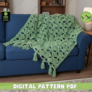 May include: A light green crocheted blanket with a textured pattern and fringe tassels, draped over a blue sofa. The blanket has a soft, plush appearance. The text "DIGITAL PATTERN PDF" is visible at the bottom of the image.