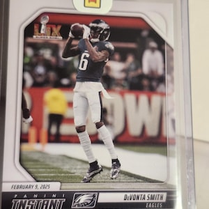 May include: A football trading card featuring Devonta Smith of the Eagles catching a football. The card has a red and white background with the text "LIX Super Bowl" and "Instant". The card is dated February 9, 2025.