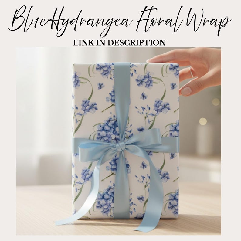 May include: A wrapped gift with a floral design featuring blue hydrangeas on a white background. The gift is tied with a light blue satin ribbon and bow. Text on the image reads "Blue Hydrangea Floral Wrap" and "LINK IN DESCRIPTION".