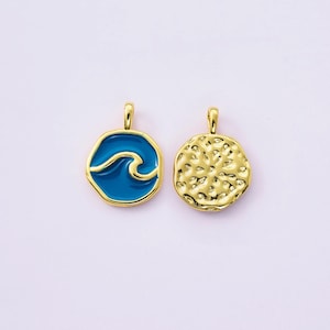 May include: Two gold-colored pendants. One pendant features a blue wave design within a gold border. The other pendant has a textured, hammered gold appearance. Both pendants have a small loop at the top for a chain.