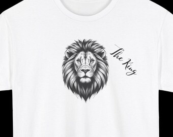 May include: White t-shirt with a black and white illustration of a lion's head and the text "The King" on the right side of the chest.
