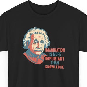 Pode incluir: T-shirt preto com um retrato de Albert Einstein em tons de vermelho, azul e laranja. O texto "IMAGINATION IS MORE IMPORTANT THAN KNOWLEDGE" está impresso em vermelho e azul. A camiseta tem gola redonda.
