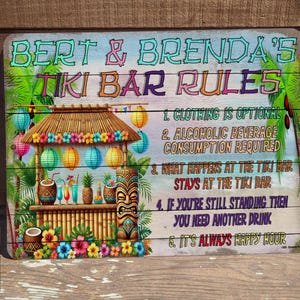 May include: A colorful Tiki Bar sign with the text "BERT & BRENDA'S TIKI BAR RULES". The sign features a tropical bar scene with a thatched roof, drinks, and a tiki statue. The rules are listed on the right.