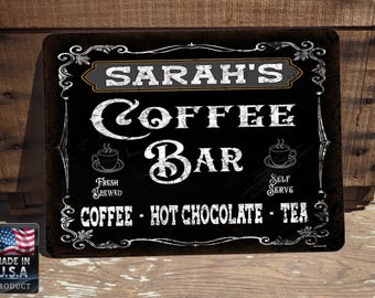 Może przedstawiać: Czarno-biały znak z tekstem "SARAH'S COFFEE BAR" w stylu vintage. Znak zawiera również tekst "FRESH BREWED" i "SELF SERVE" z obrazkami filiżanek do kawy. Znak zawiera również tekst "COFFEE - HOT CHOCOLATE - TEA".
