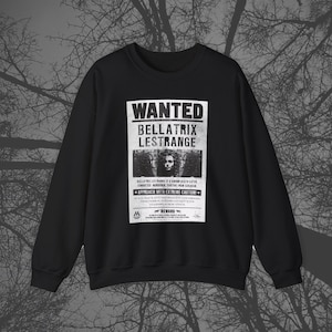 May include: Black crewneck sweatshirt featuring a white graphic of a "Wanted" poster. The poster displays the name "Bellatrix Lestrange" with a portrait and the warning "Approach with Extreme Caution!" The sweatshirt is a dark, solid color.