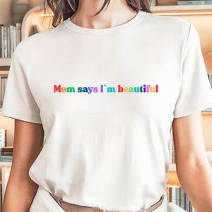 Camiseta "Mãe Diz Que Sou Linda" | Camiseta com Texto do Orgulho do Arco-Íris | Camiseta com Afirmação Queer | Presente LGBTQ+ Engraçado | Blusa com Tipografia Colorida