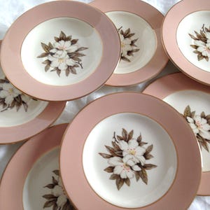 May include: Set of six pink and white floral patterned dessert plates with gold trim.