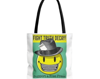 Puede incluir: Bolsa de tela blanca con un gráfico verde y amarillo. El gráfico presenta una cara sonriente que lleva un fedora con una nota de "Prensa" en él. El texto "Fight Truth Decay!" y "Support a Free Press" también están en la bolsa.