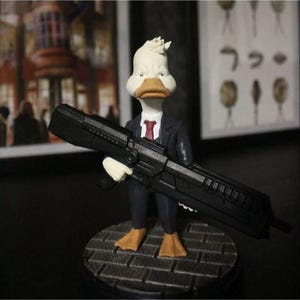 Figurina del detective Paperino: divertente personaggio dei cartoni animati stampato in 3D con arma gigante