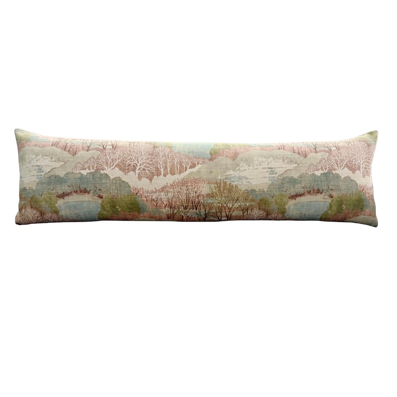 Long lumbar pillow cover featuring a soft pastel pastoral landscape with rolling hills, delicate trees, and serene ponds in blush pink, sage green, cream, and muted blue. This decorative linen lumbar pillow offers timeless English cottage, grandmillennial, and traditional home décor style, making it perfect for beds, sofas, benches, and cozy reading nooks.