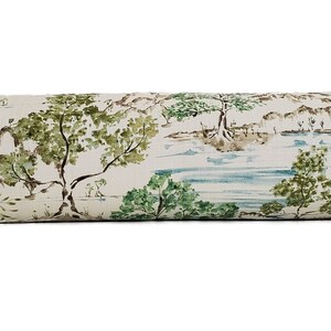 May include: A long, cylindrical cushion with a white background and a repeating pattern of green trees, brown mountains, and blue water. The cushion is ideal for adding a touch of nature to any room.