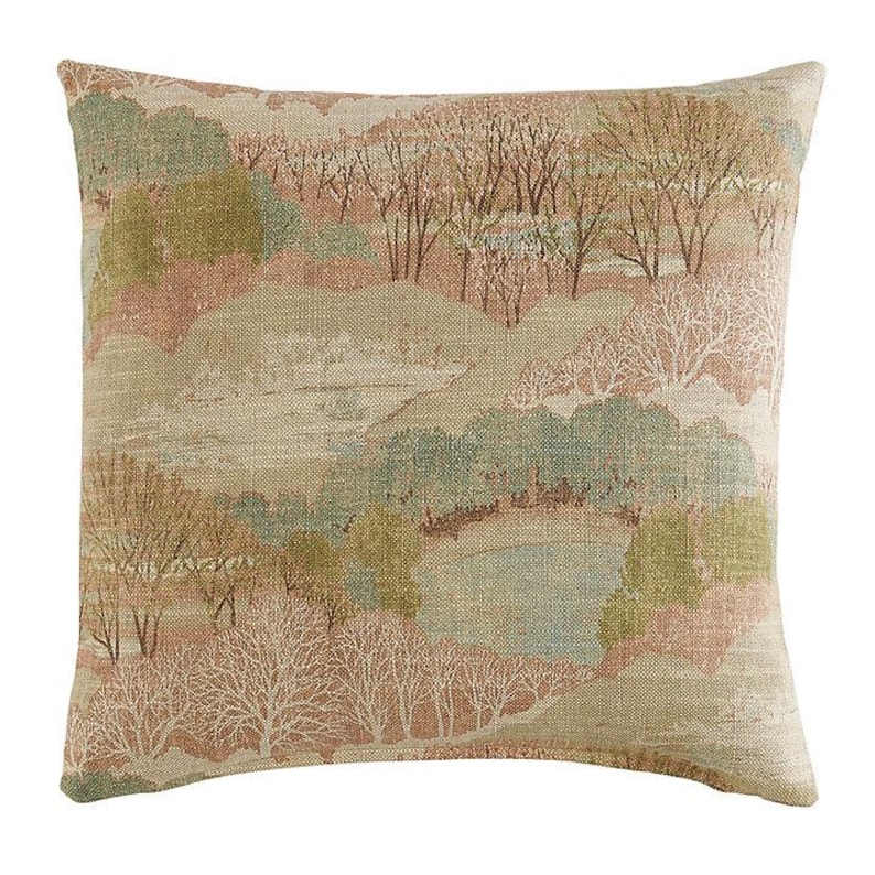 May include: Square decorative pillow with a landscape design. The pillow features a beige background with a pattern of trees, hills, and a body of water in shades of green, brown, and white. The pillow has a textured appearance.