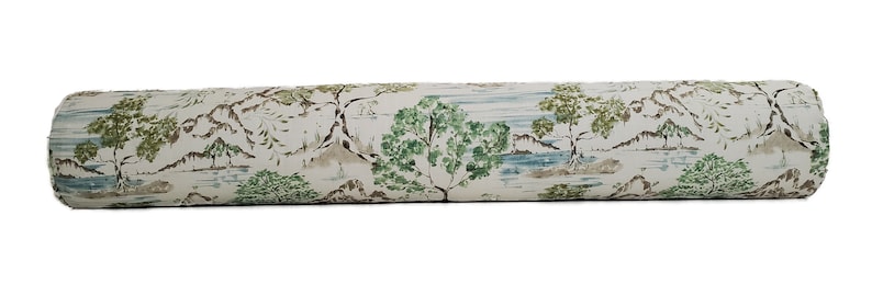 May include: A white bolster cushion with a green and brown landscape print. The print features trees, mountains, and water.