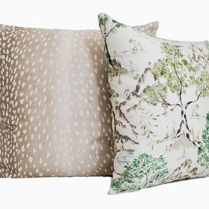 May include: Two decorative throw pillows, one with a brown and white deer print and the other with a green and white floral print.