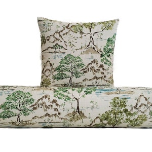 May include: A white bolster cushion with a green and brown landscape print. The cushion is paired with a square throw cushion with the same print.