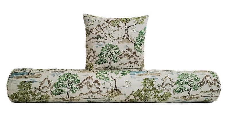 May include: A white bolster cushion with a green and brown landscape print. The cushion is paired with a square throw cushion with the same print.