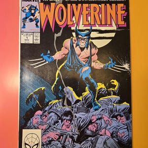 May include: A comic book cover featuring Wolverine, a superhero with claws, in a blue and black costume. He is standing on a pile of bodies, with a moon in the background. The cover text reads "MARVEL AT LAST - IN HIS OWN MONTHLY SERIES! WOLVERINE".