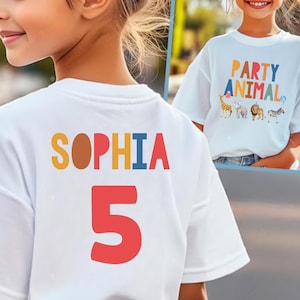 Pu&ograve; includere: Maglietta bianca con il nome "SOPHIA" in lettere colorate e il numero "5" in rosso. La parte anteriore della maglietta nell'immagine ha la scritta "PARTY ANIMAL" con illustrazioni di animali. La maglietta &egrave; probabilmente per il compleanno di un bambino.