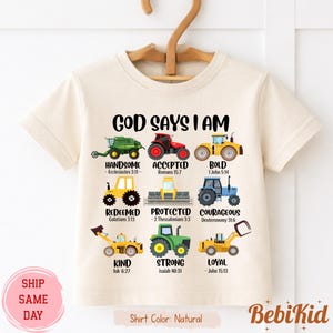 Peut inclure: Un t-shirt de couleur naturelle avec l'inscription "GOD SAYS I AM" au-dessus d'illustrations de tracteurs colorés. Chaque tracteur est associé à une affirmation positive et à une référence biblique. Le t-shirt porte également l'inscription "Shirt Color: Natural".
