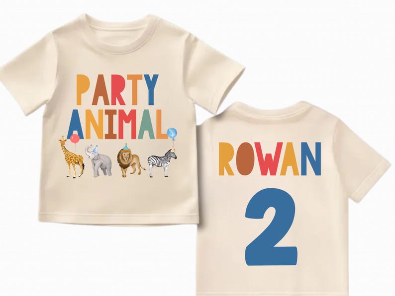 Pu&ograve; includere: Una maglietta color crema con le parole "PARTY ANIMAL" in lettere colorate e illustrazioni di animali. Il retro della maglietta presenta il nome "ROWAN" e il numero "2" in colori vivaci. Una divertente maglietta di compleanno.