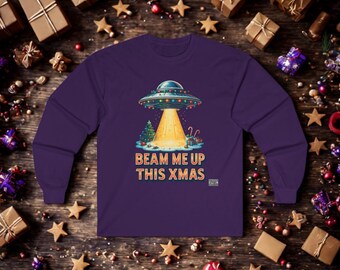 May include: A long-sleeved purple shirt featuring a graphic of a UFO with Christmas lights, beaming a light down onto a Christmas tree and presents. The text "BEAM ME UP THIS XMAS" is printed below the graphic.